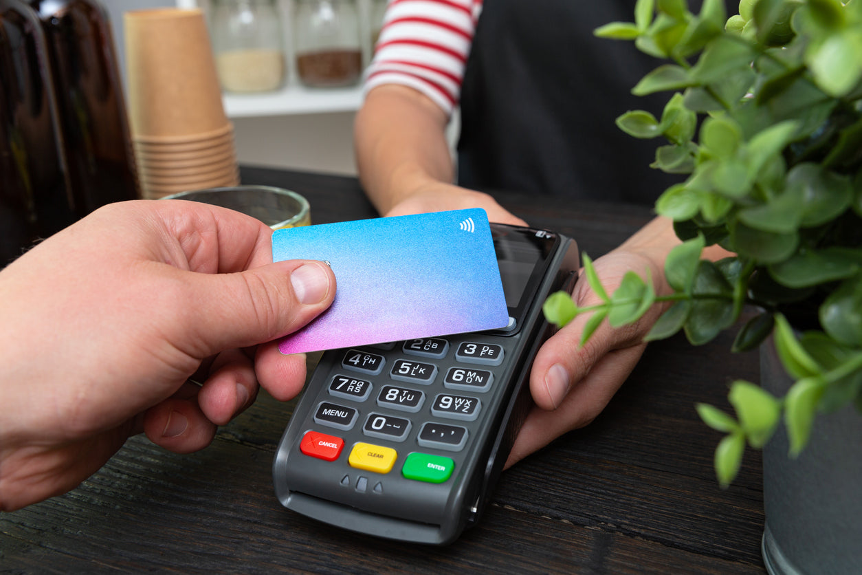 A photo of a handheld credit card terminal in use by a customer at a merchant location. 